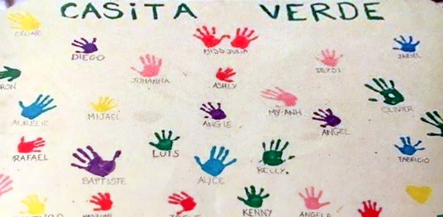 La Casita Verde — panneau d'empreintes de mains colorées avec les prénoms des enfants parrainés